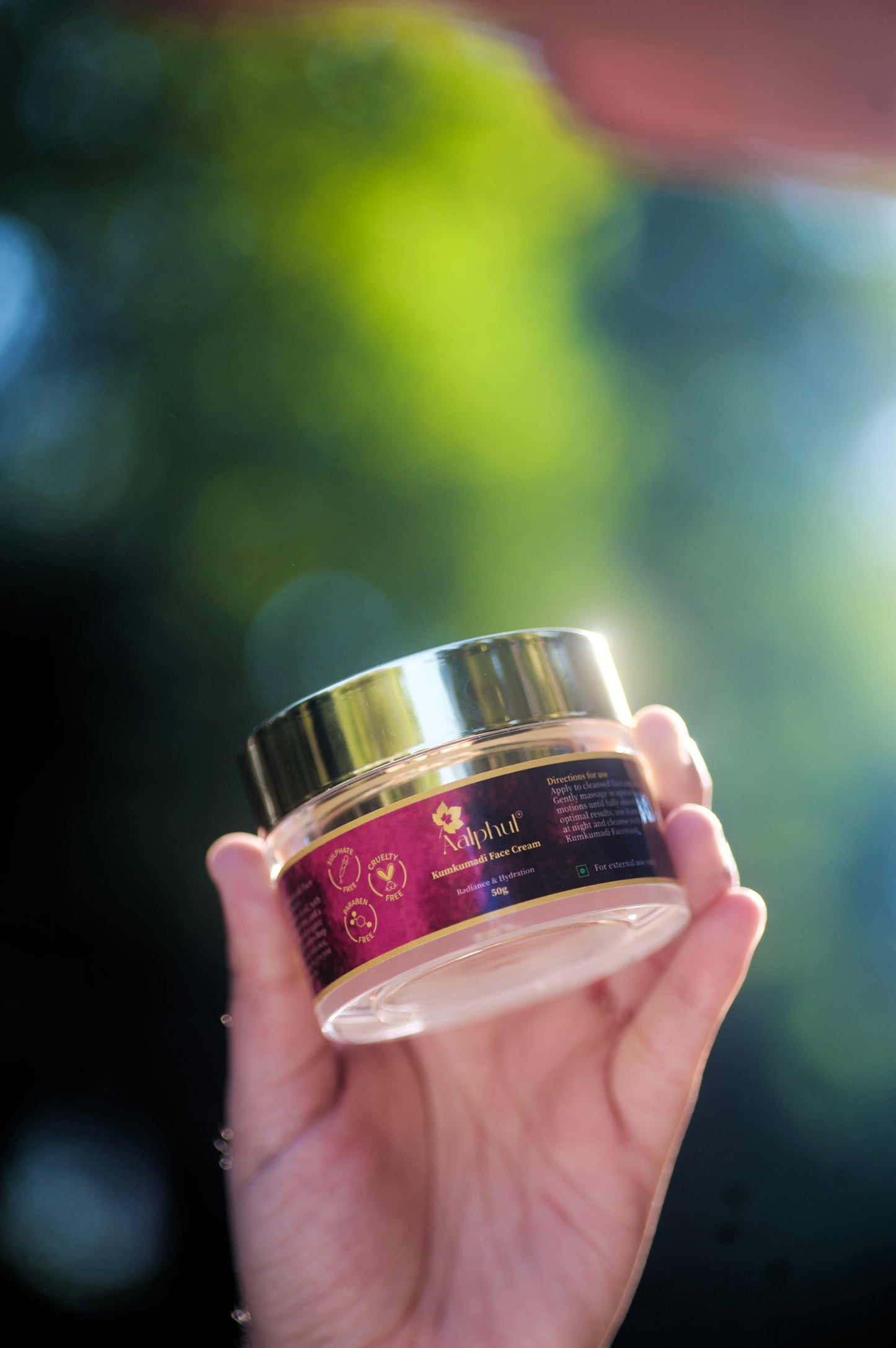 Aalphul Kumkumadi Face Cream bottle held in a hand