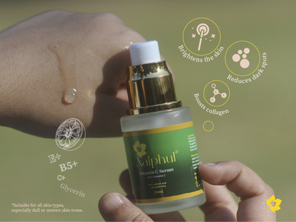 Aalphul Vitamin C Serum bottle held by a hand with green background showing the benefits printed on the bottle label 