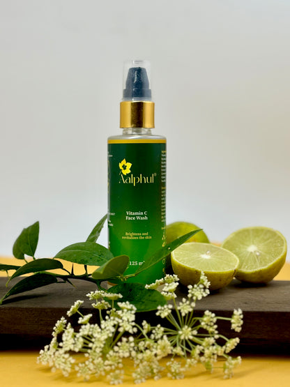 Aalphul Vitamin C Face Wash Bottle displayed with lemons and other natural ingredients