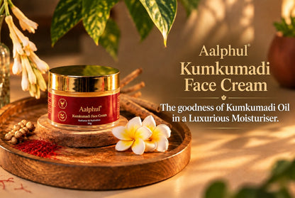 A jar of Aalphul Kumkumadi Face Cream sits on a round wooden tray, styled with a saffron strands and green botanicals in a warm, sunlit setting. 